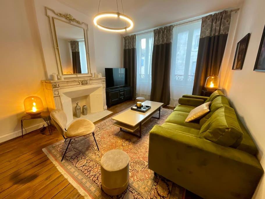 a living room with a green couch and a fireplace at Maison Verdun Centre "L'Aparté" - Terrasse - Wifi - 8 personnes - Géré Par PrestaZen'Services in Verdun
