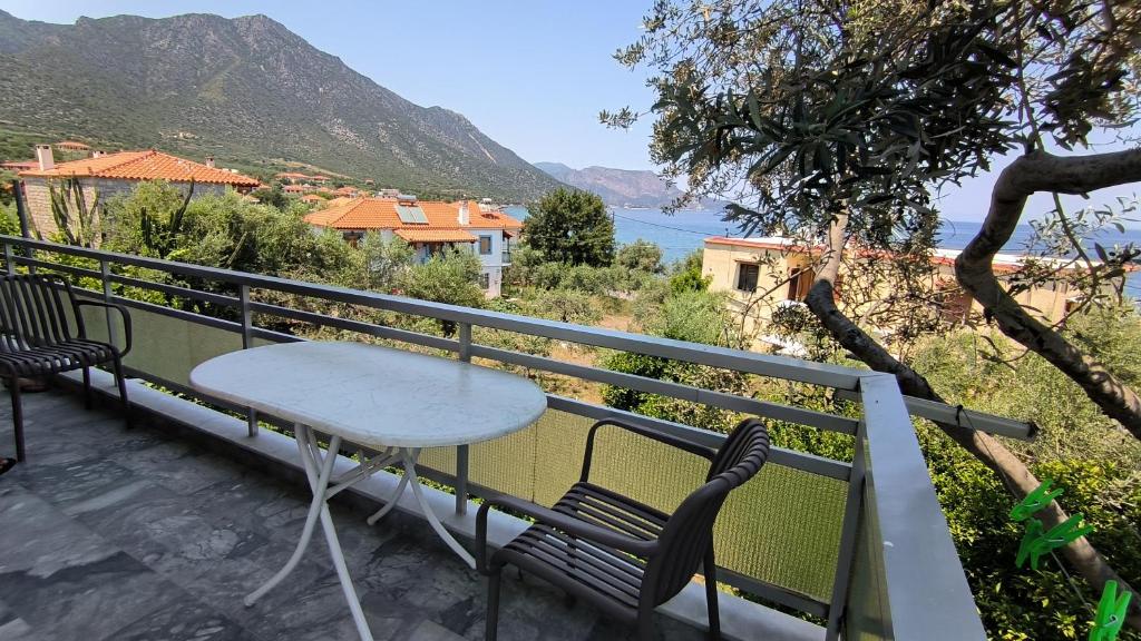 a table and chairs on a balcony overlooking the water at Ntaskas apartments in Poulithra