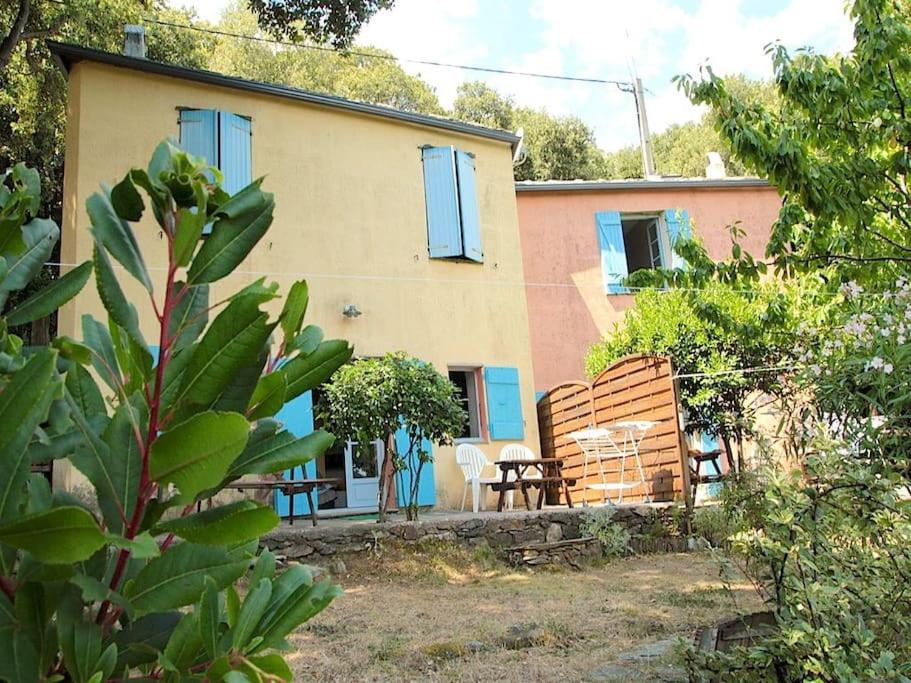 une maison avec une table et des chaises devant dans l'établissement Gite du bout du cap Corse, à Ersa