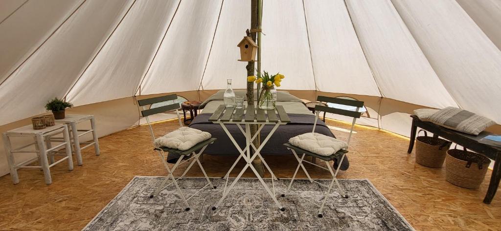a tent with a table and chairs in a room at Petit a Petit - gypsy wagons and Bell tents in the Bourgogne in Saisy