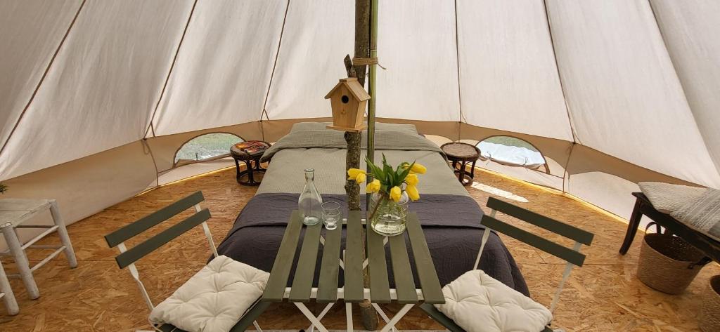 a table in a tent with flowers on it at Petit a Petit - gypsy wagons and Bell tents in the Bourgogne in Saisy