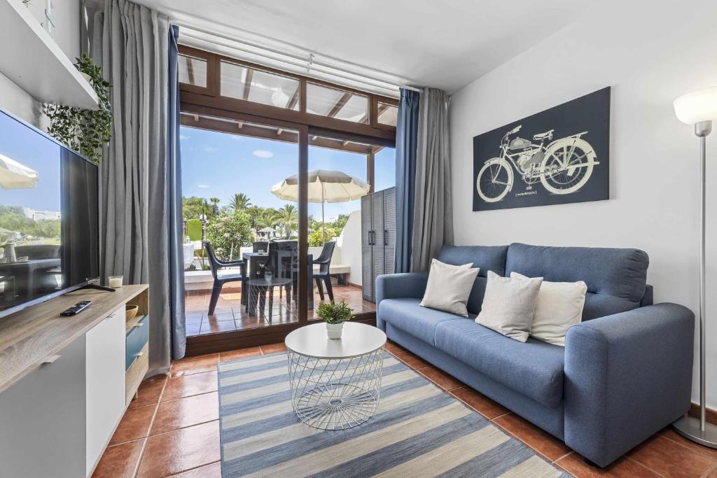 a living room with a blue couch and a table at Holyhome mills 1113 in Costa Teguise