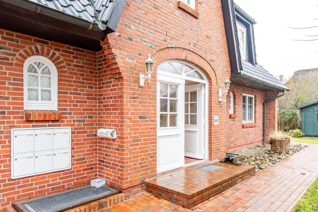 una casa in mattoni con una porta bianca e un portico di Heefwai-2-W5 a Morsum