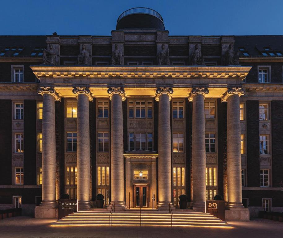 un grande edificio con colonne di fronte ad esso di The Wellem, in The Unbound Collection by Hyatt a Dusseldorf
