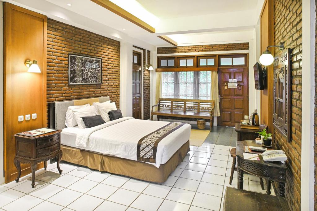 Habitación de hotel con cama y escritorio en Paku Mas Hotel, en Yogyakarta