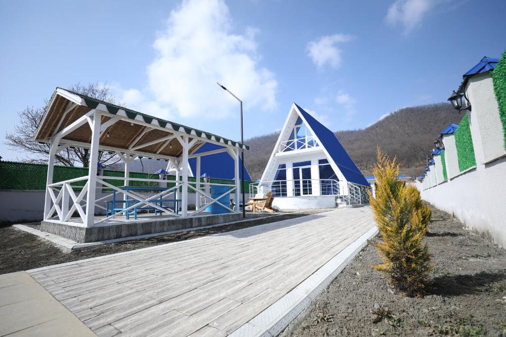 a blue and white building with a wooden deck at Mirvari Aframe in Quba