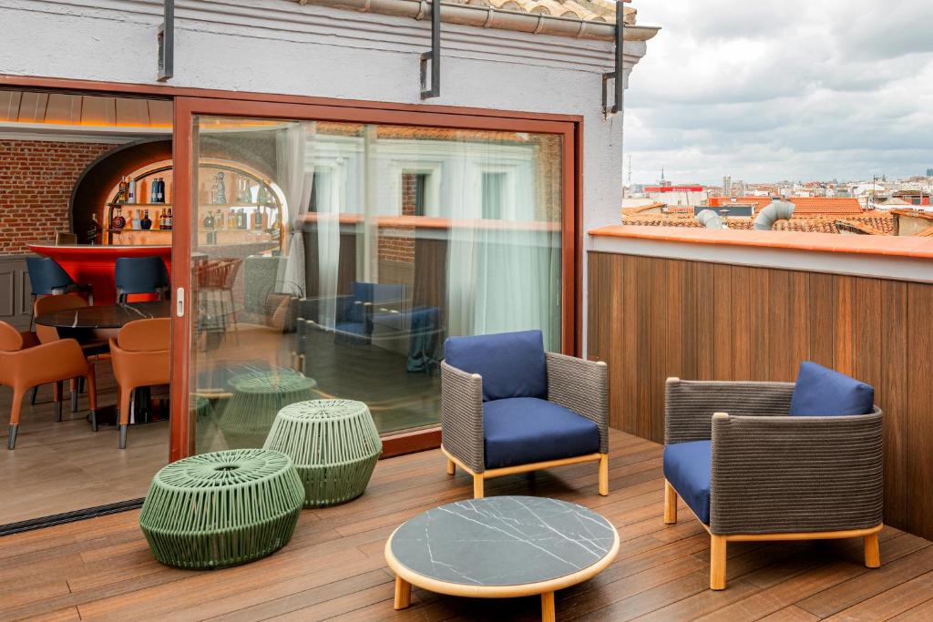 a balcony with chairs and a table on a building at Casa Faraona Luxury Residences in Madrid