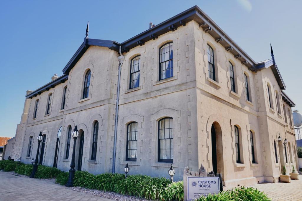 a large stone building with a sign in front of it at The Customs House Port MacDonnell in Port MacDonnell