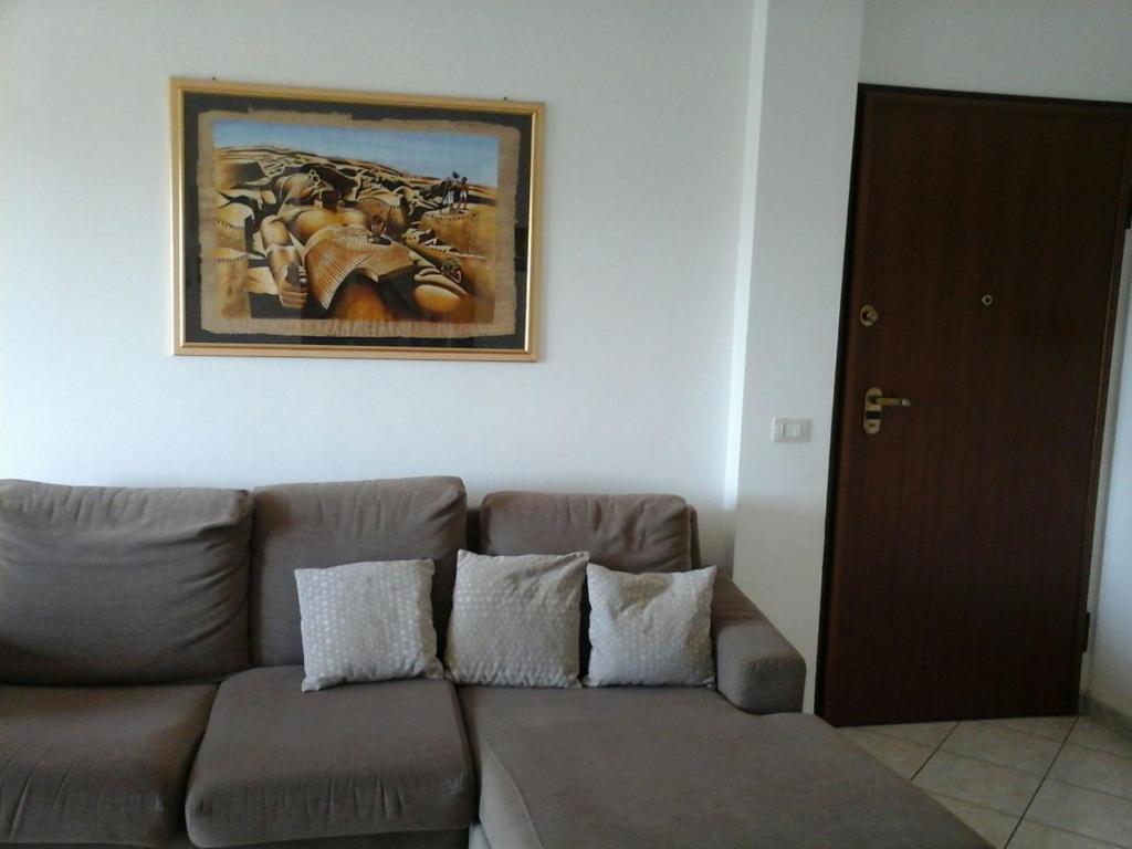 - un salon avec un canapé et une photo sur le mur dans l'établissement Appartamento Fiore, à Alghero