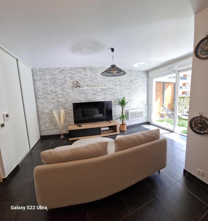 un salon avec un canapé et une télévision à écran plat dans l'établissement Appartement cosy proche du stade et de la plage, à Marseille