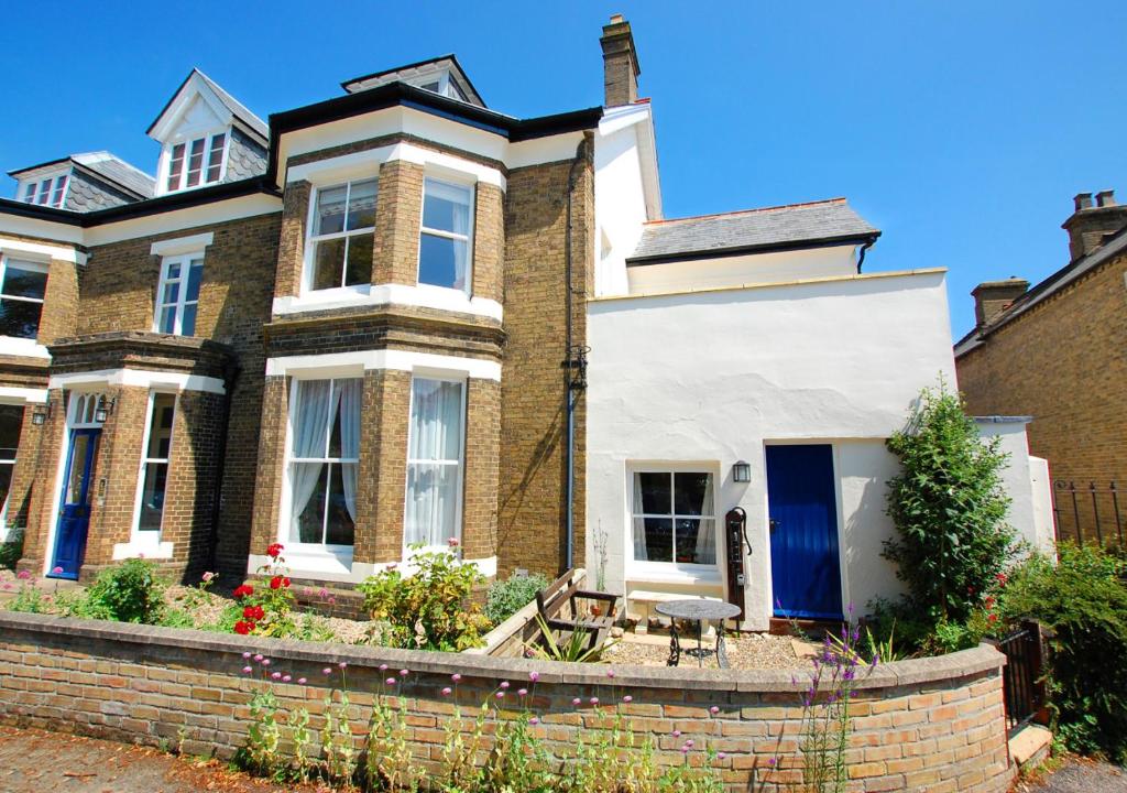 a large brick house with a blue door at South Flat in Wells next the Sea