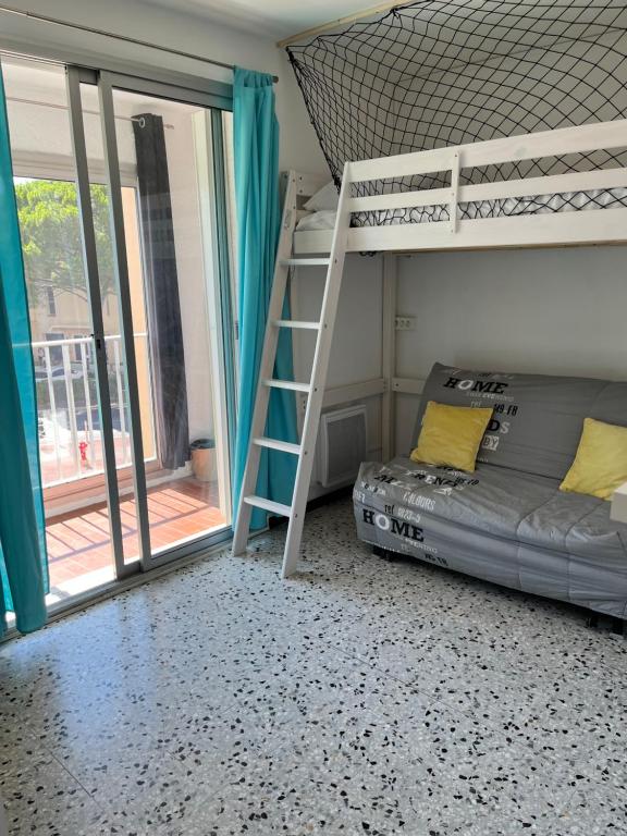 une chambre avec un lit superposé et une échelle dans l'établissement Studio Aquarium Canet, à Canet