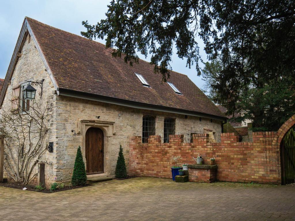 an old brick church with a brick wall at The Stables at Stoneythorpe in Southam