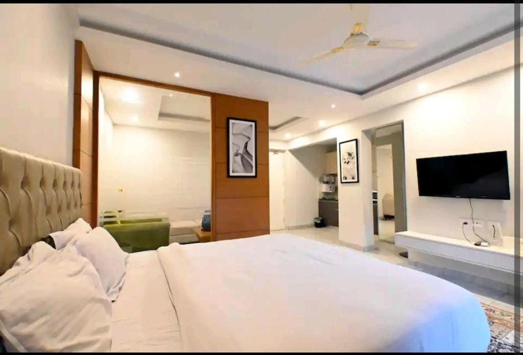 een slaapkamer met een groot bed en een flatscreen-tv bij Angel homes in Ghaziabad