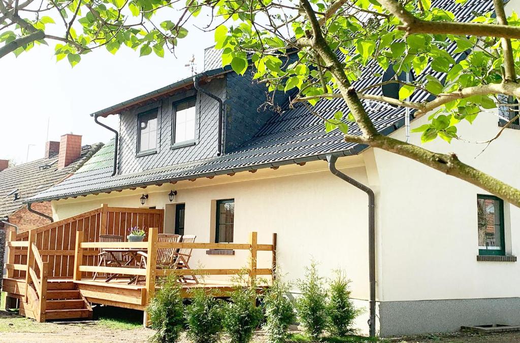 a house with a porch and a deck at Ferienwohnung "Perle im Grünen" in Federow