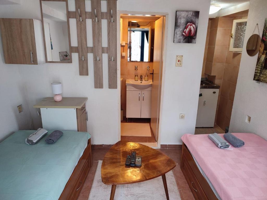 um pequeno quarto com duas camas e uma mesa em Bay Mola Home em Kotor