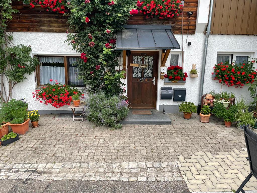una casa con flores y plantas delante de ella en Gästehaus Möschel en Weiler-Simmerberg