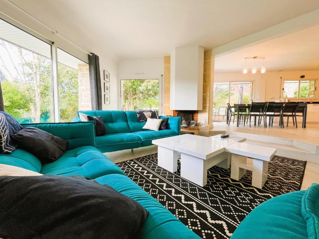 un salon avec un canapé bleu et une table dans l'établissement Fouesnant, Cap Coz, superbe maison familiale, plage et sentiers à pied, à Fouesnant