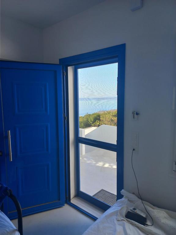 Habitación con puerta azul y ventana en Relax, en Pírgos