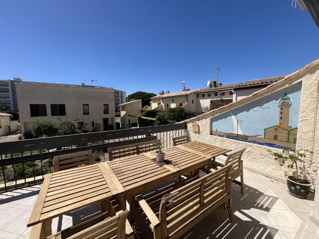 une table en bois assise au-dessus d'un balcon dans l'établissement Maison provençale (parking et vélos à disposition), au Grau-du-Roi