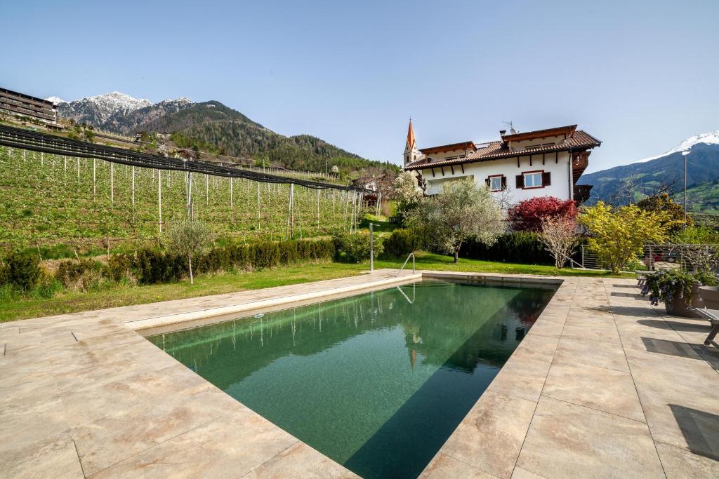 a swimming pool in front of a house with mountains at Gasserhof Ferienwohnung Morgenduft in Caines