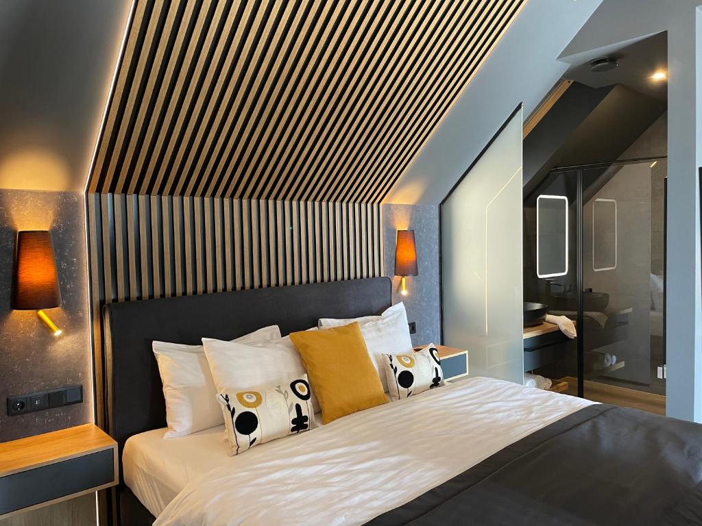 una camera da letto con un grande letto bianco con cuscini di M26 Prémium apartmanok a Tihany