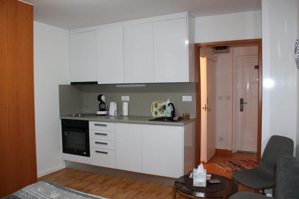 uma cozinha com armários brancos e um fogão em Cozy apartment Ladybug, Sarajevo em Sarajevo