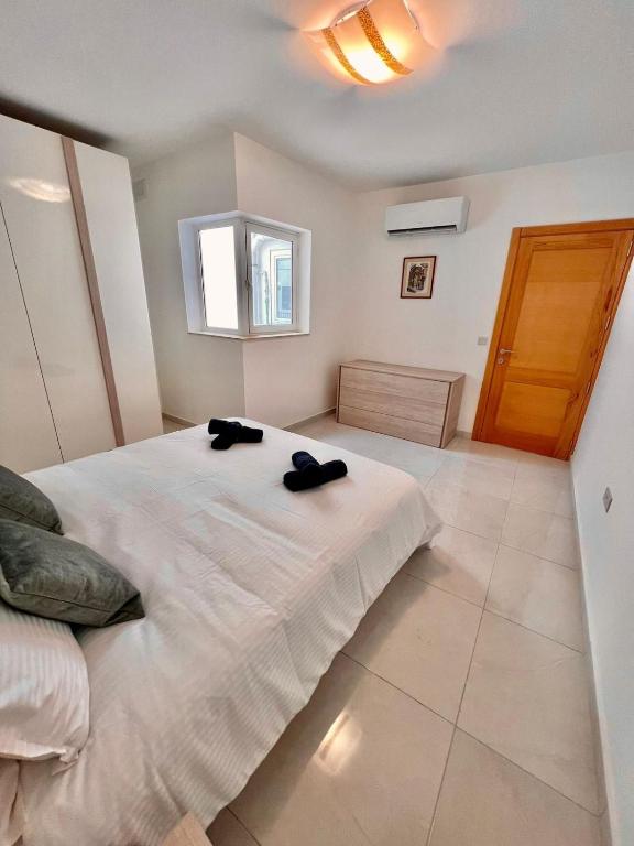 a bedroom with a large bed with two black shoes on it at Msida Central Suites in Msida