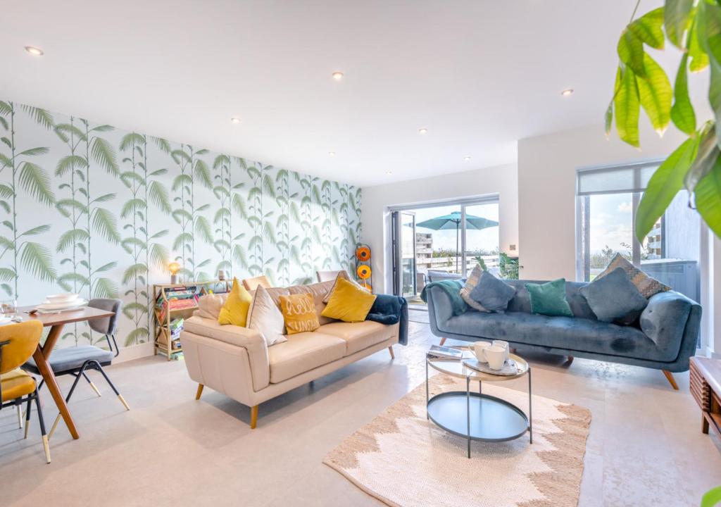 uma sala de estar com dois sofás e uma mesa em Sandy Toes - Dartmouth em Stoke Fleming