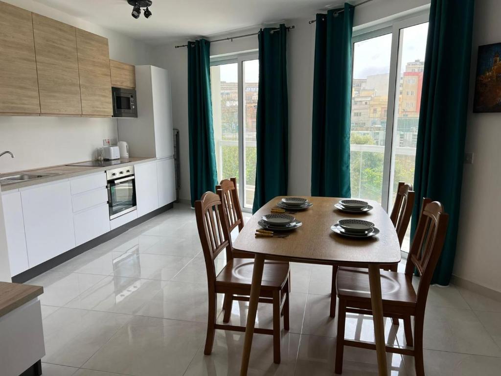 a kitchen and dining room with a table and chairs at Msida Central Suites in Msida