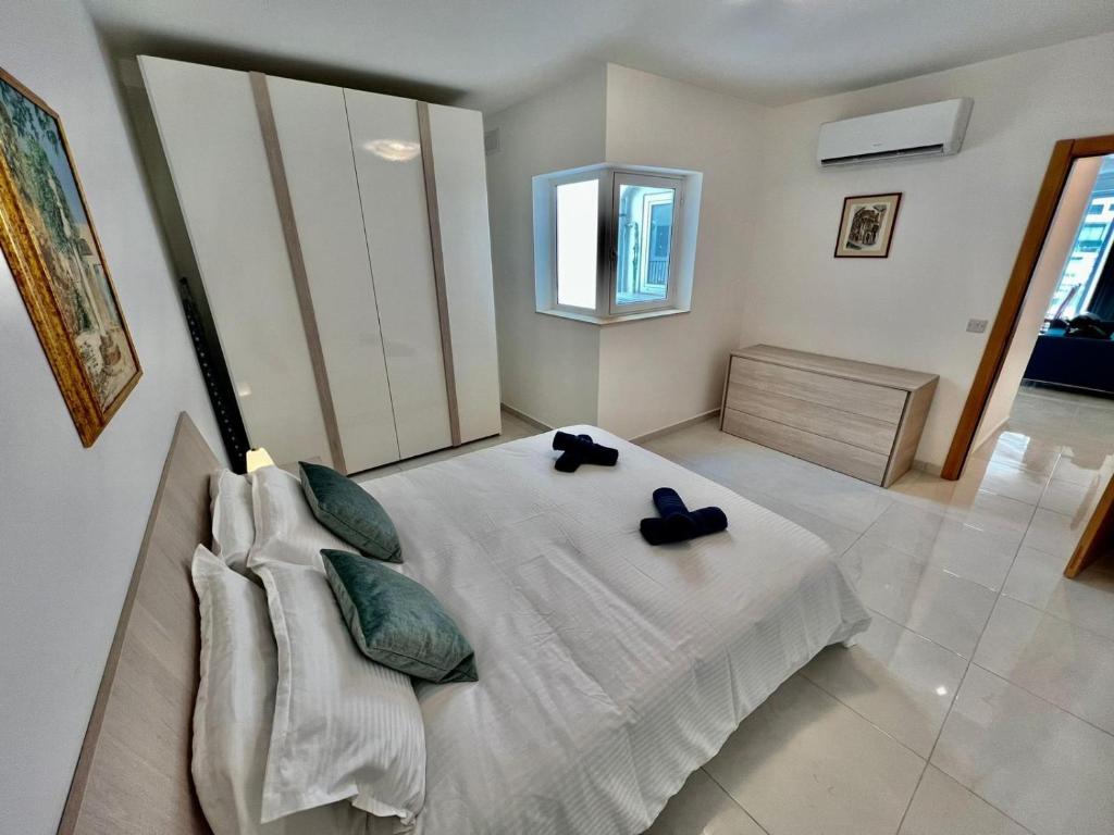 a bedroom with a bed with two pillows at Msida Central Suites in Msida