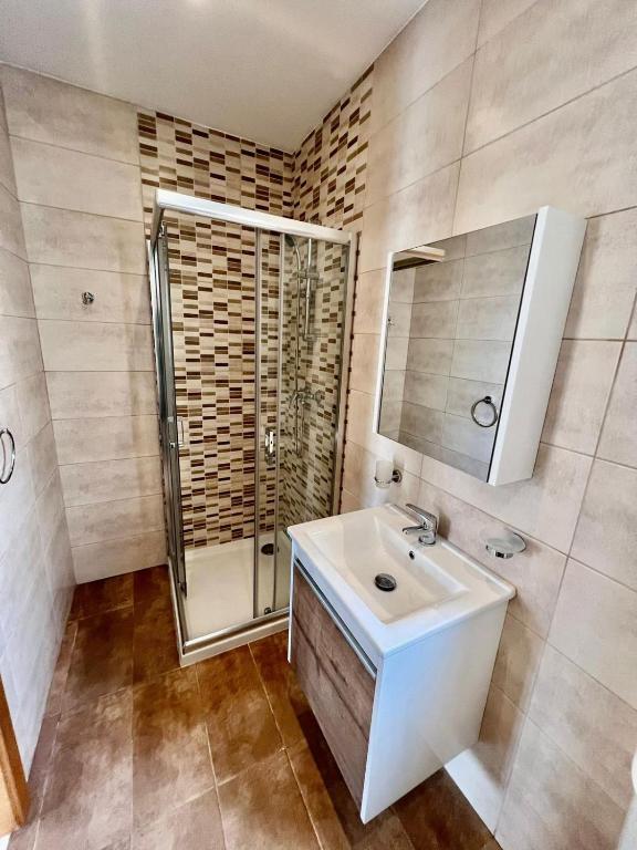 a bathroom with a white sink and a shower at Msida Central Suites in Msida