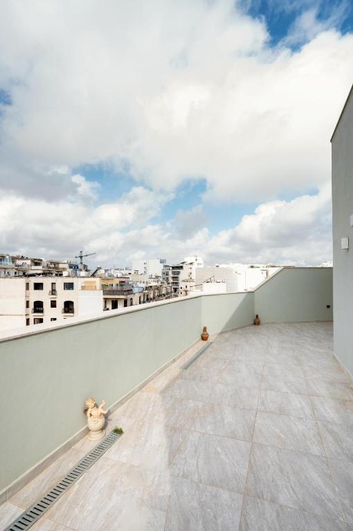an apartment balcony with a view of a city at Msida Central Suites in Msida