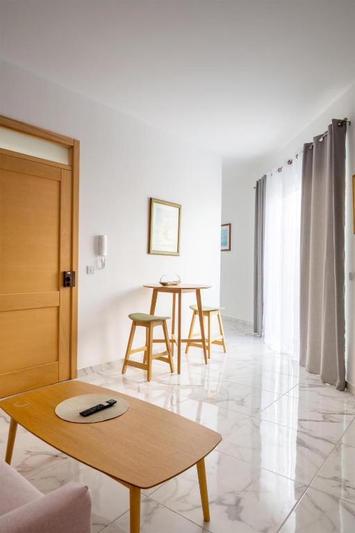 a living room with a table and chairs at Msida Central Suites in Msida