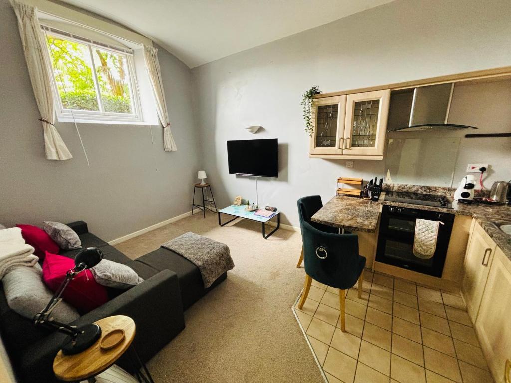 a living room with a couch and a kitchen at County House City Centre with parking Sleeps 4 in York