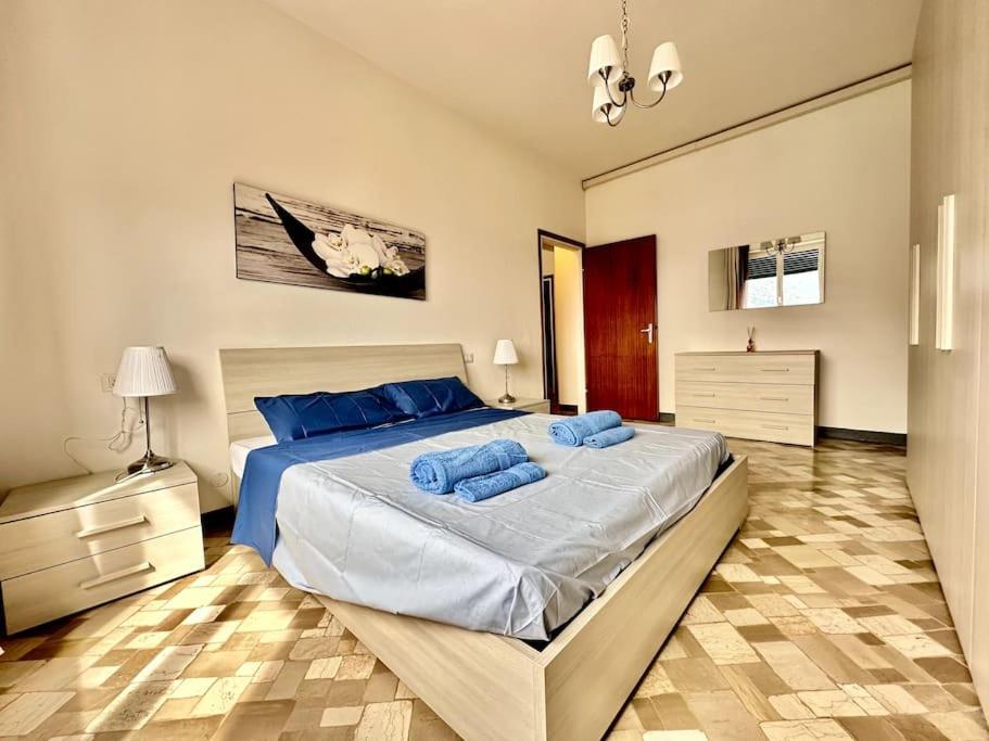 a bedroom with a large bed with blue pillows at [Free parking] Relax in the magic Garden in Pognana Lario