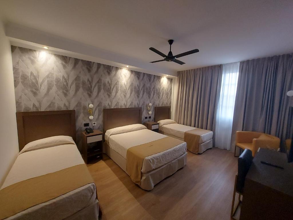 um quarto de hotel com 2 camas e uma ventoinha de tecto em Hotel Internacional em Buenos Aires