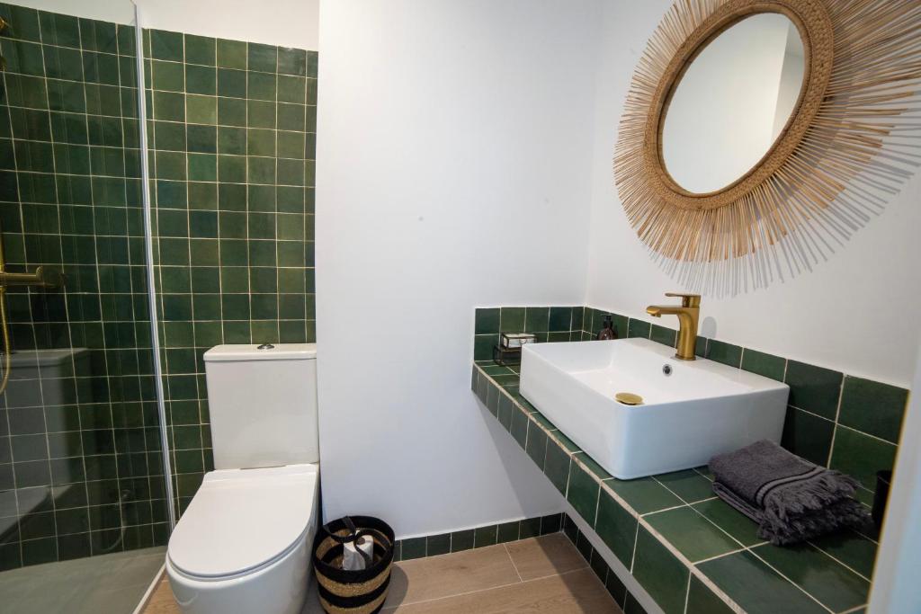 y baño con lavabo, espejo y aseo. en Exquisito apartamento en el Centro San Francisco 2 en Gandía