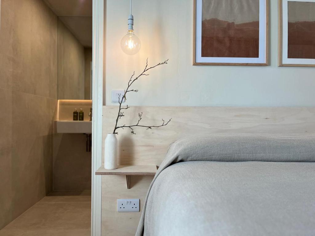 a bedroom with a bed and a pendant light at Salt Cliff Cottage in Doolin