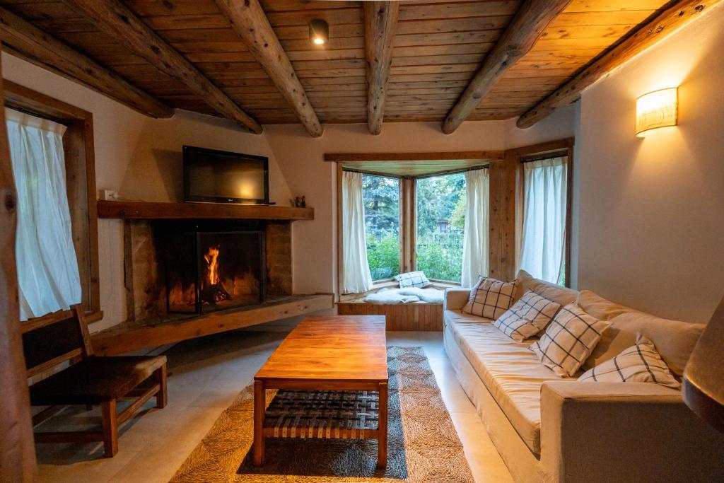 een woonkamer met een bank en een open haard bij Luna Roja Llao Llao in Bariloche