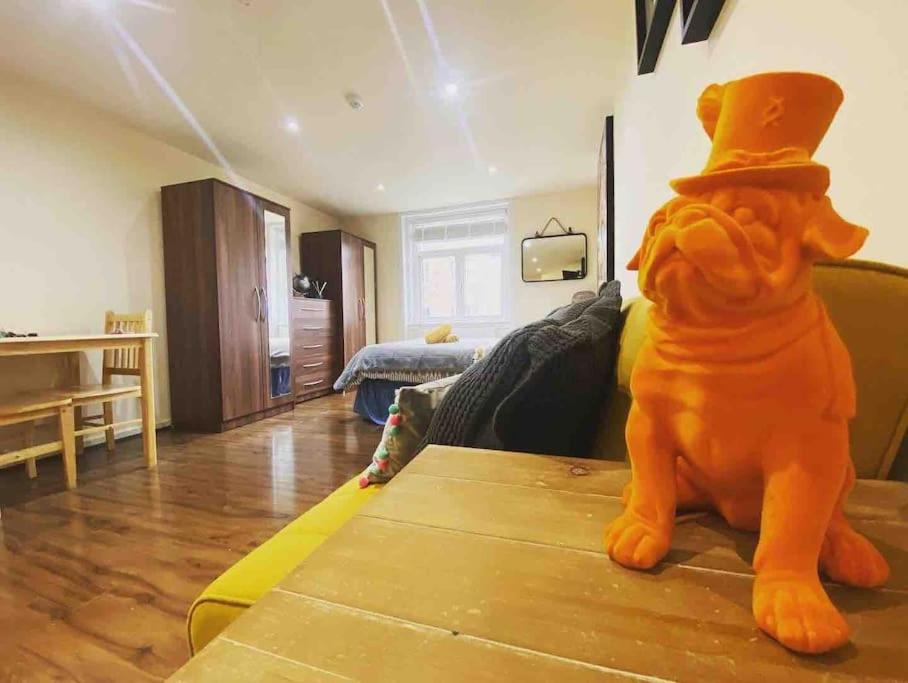 a dog wearing a top hat sitting on a table in a living room at Studio flat London in London