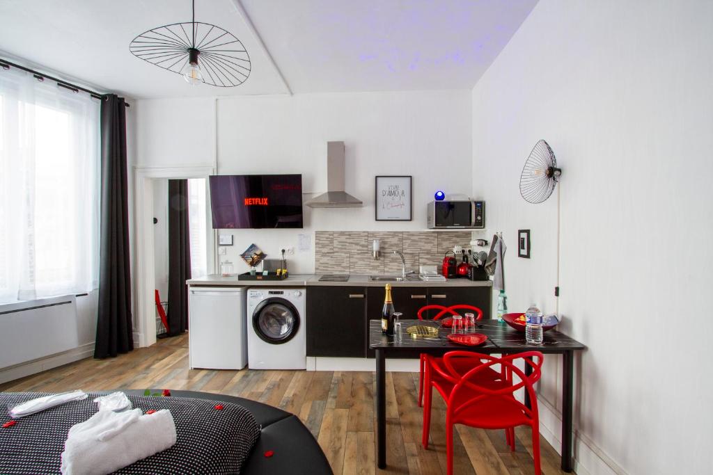 uma cozinha com uma mesa e cadeiras vermelhas num quarto em L'Hyper Centre - Netflix & Wifi - Lit Haut de Gamme & Sofa Tantra - check-in 24H24 - GoodMarning em Châlons-en-Champagne