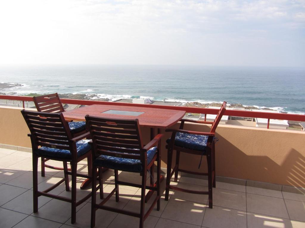 a table and chairs on a balcony overlooking the ocean at Del Este 10 in Margate