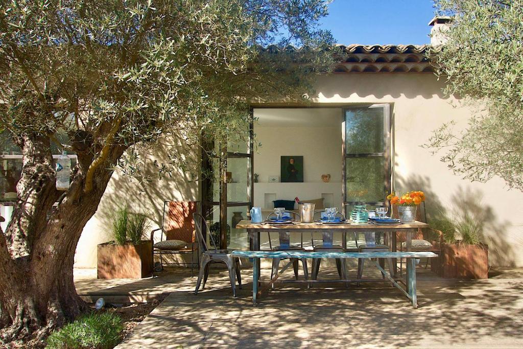 a table in a yard next to a tree at La Matina Family Haven with Olive Garden Oasis in Lauris