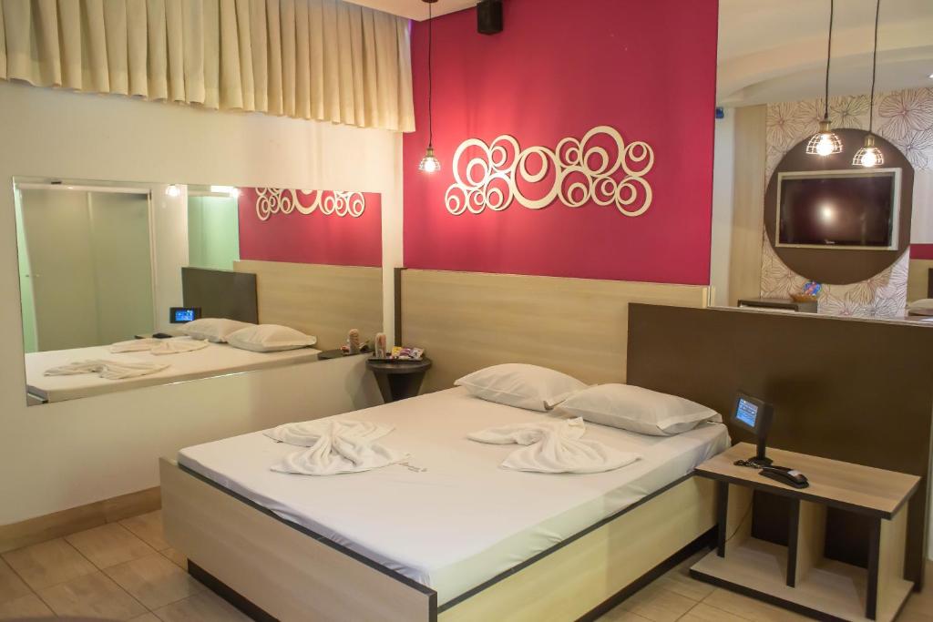 una camera con due letti e una tv di Luna's Motel a Sumaré