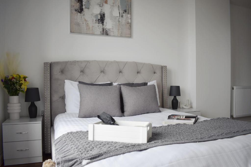 Un dormitorio con una cama blanca con una caja. en Stunning 2 bed with balcony in Brentwood Essex en Brentwood