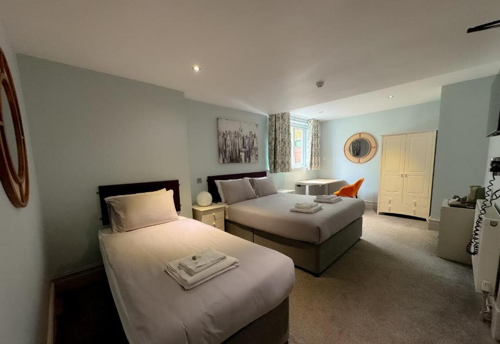 pokój hotelowy z 2 łóżkami i kanapą w obiekcie Nomi Rooms & Restaurant w mieście Bangor