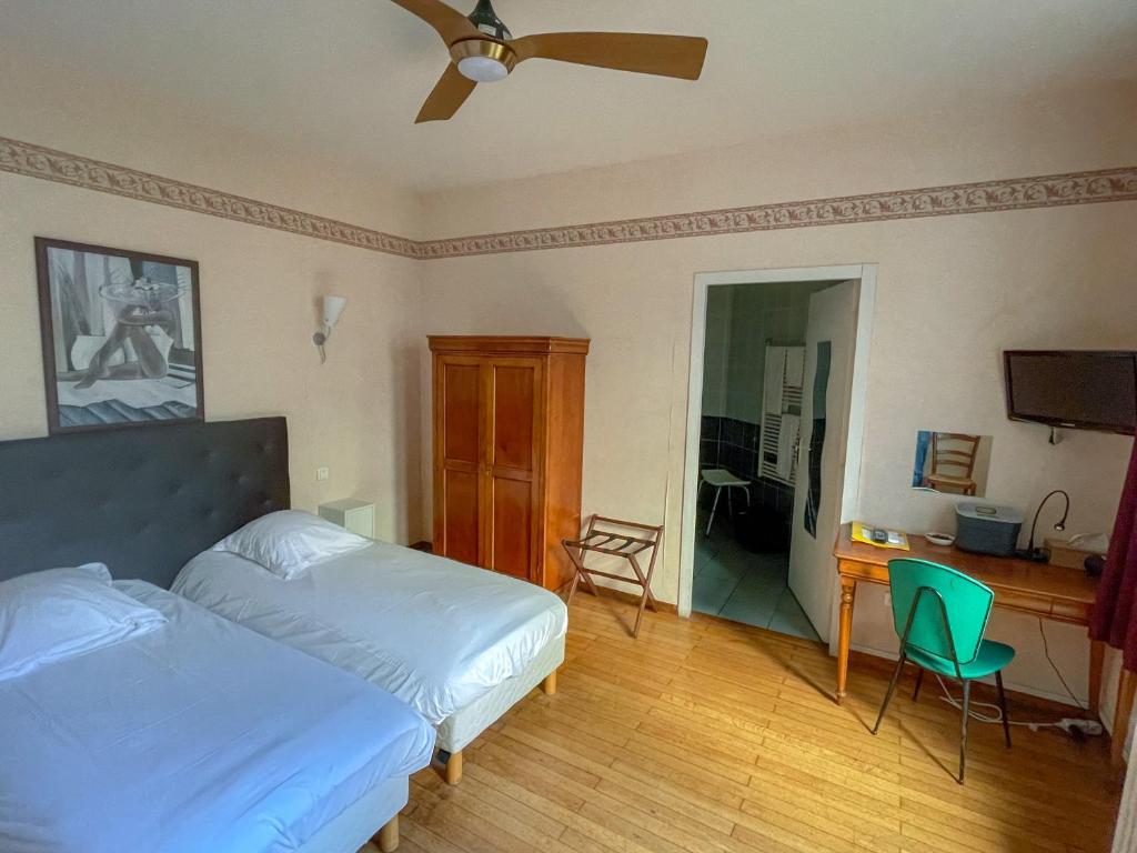 - une chambre avec un lit, un bureau et une chaise dans l'établissement Hôtel de Verdun, à Nevers