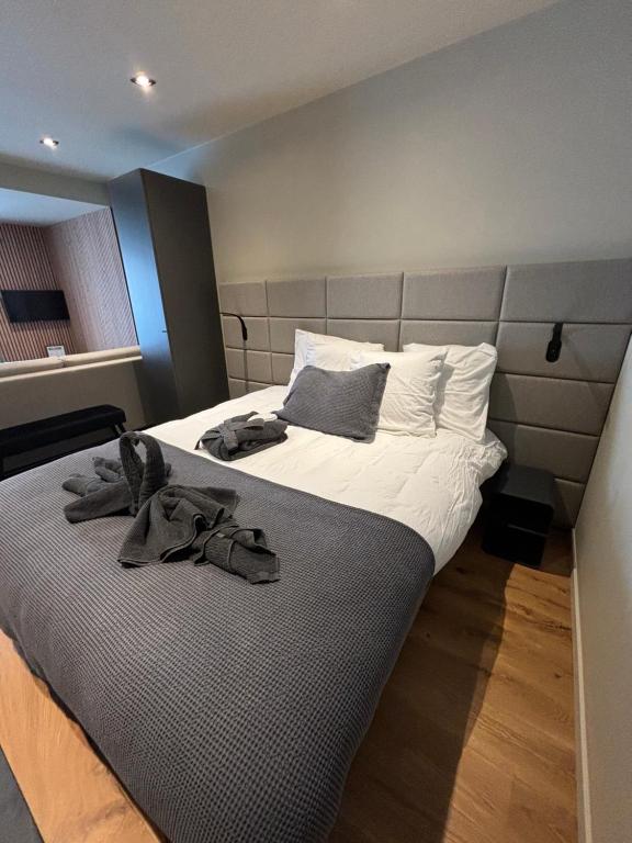 een slaapkamer met een groot bed en handdoeken bij Hotel Mezza Notte in Ronse