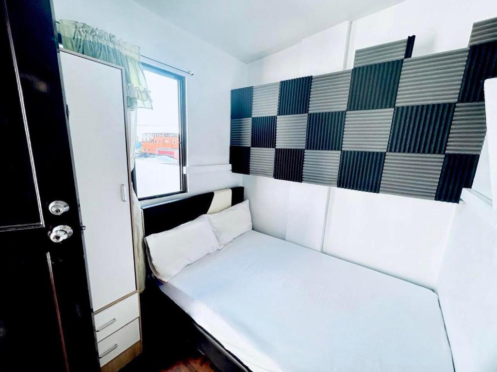 a small room with a white couch and a window at Semi Studio Room at EKG House Rental in Manila
